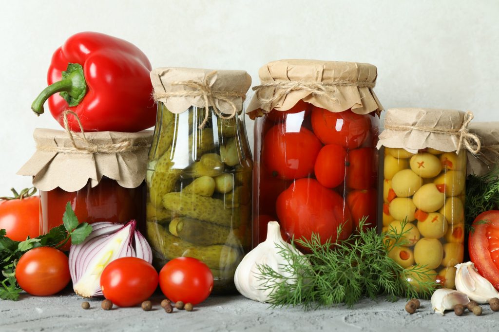 Different canned food and ingredients on gray table